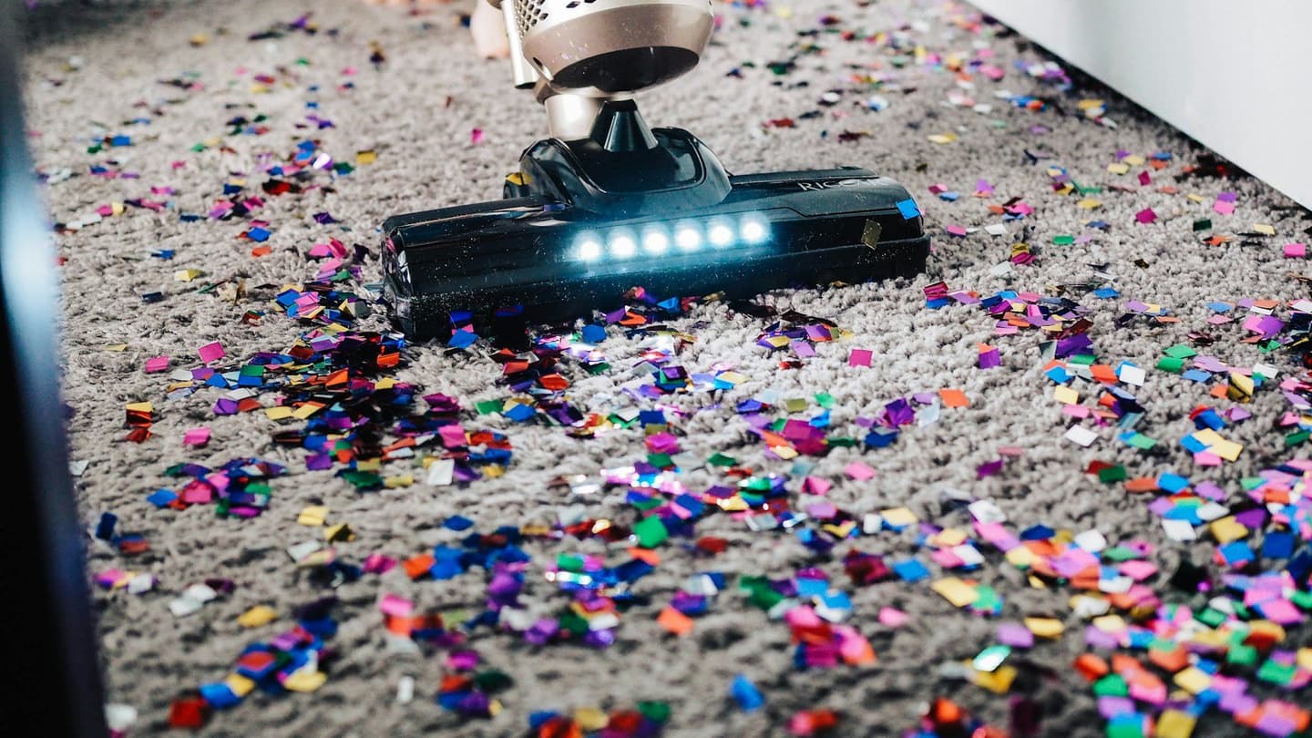 Vacuum cleaning confetti from a living room carpet